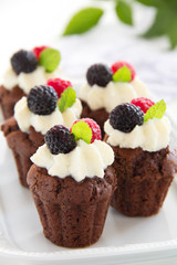 Chocolate muffins with raspberries and cream.