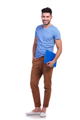 full body picture of a young casual man holding  notepad