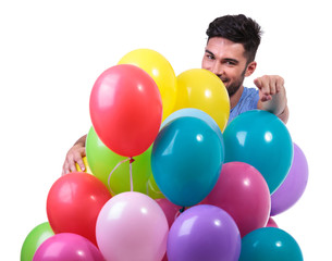 Fototapeta na wymiar casual man behind a bunch of baloons is pointing finger