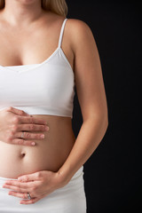Close Up Portrait Of 4 months Pregnant Woman On Black Background