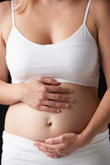 Close Up Portrait Of 4 months Pregnant Woman On Black Background