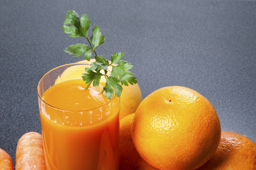 Orange and carrot juice in glass with ginger, fresh vegetables a