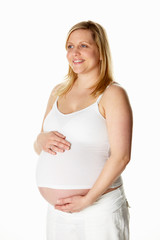 Studio Portrait Of 8 Months Pregnant Woman Wearing White