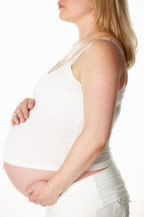 Close Up Studio Portrait Of 8 Months  Pregnant Woman Wearing Whi