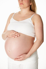 Close Up Studio Portrait Of 8 Months Pregnant Woman Wearing Whit