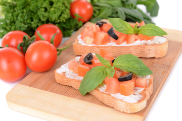 Delicious bruschetta with tomatoes on cutting board close-up