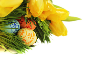 Easter eggs in grass with tulips