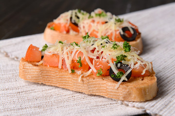 Delicious bruschetta with tomatoes on table close-up