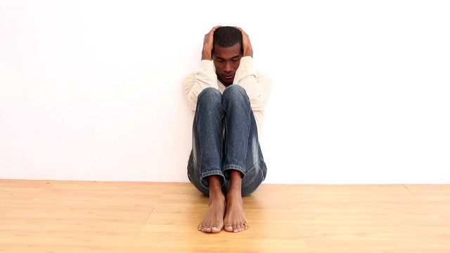 Anxious man sitting on the floor