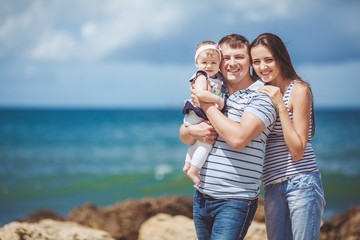 Portrait of a family of three having fun together on the ocean
