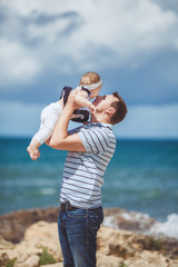 Happy father and little daughter having fun at the blue sea