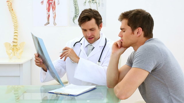 Smiling doctor discussing xray with his patient
