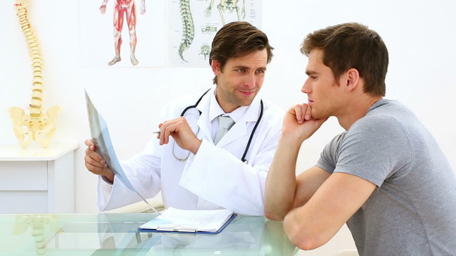 Handsome doctor discussing xray with his patient