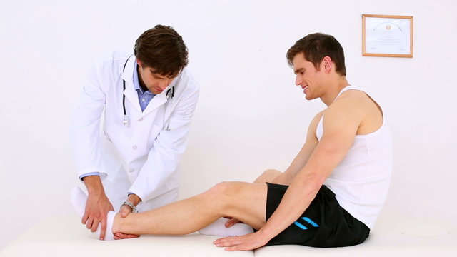 Doctor checking patients injured ankle