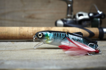 colorful lures with the fishing rod on the wooden pier