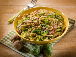 pasta with ham brussel sprout and nuts, selective focus