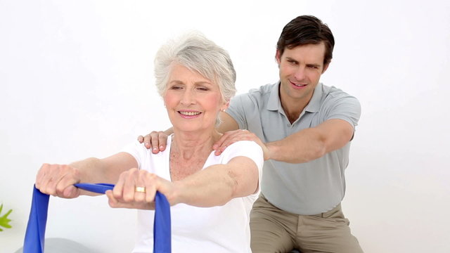 Physiotherapist checking senior patients shoulder alignment