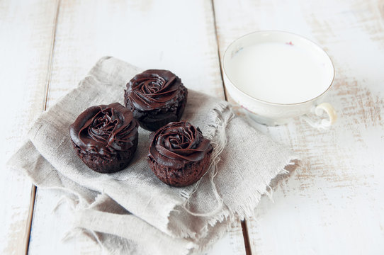 Chocolate muffins decorated with cream in the form of roses