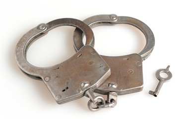 Handcuffs with a key on white