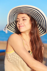 Beautiful woman in hat joying sunny summer day and looking