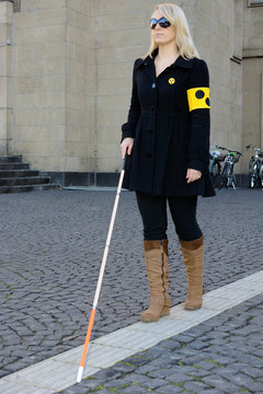 Blinde Frau mit Blindenstock und Armbinde Stock Photo | Adobe Stock
