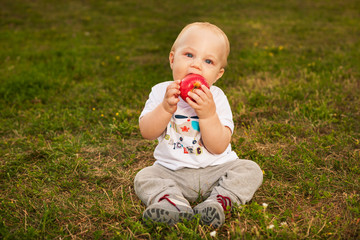 Baby with apple outdoors