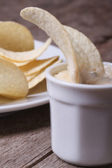 Potato chips in a white sauce macro. Vertical