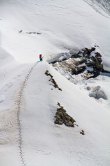 Fototapeta premium Skier climbing a snowy mountain