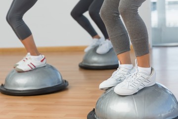 Low section of fit people performing step aerobics exercise