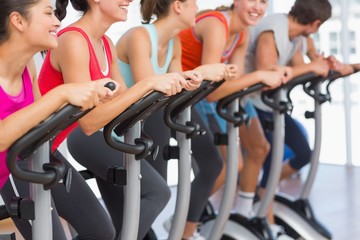 Fit people working out at spinning class