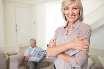 Obraz premium Smiling woman with man reading newspaper at home