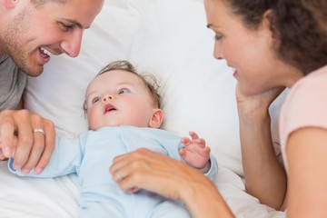 Fototapeta na wymiar Parents looking at baby boy in bed