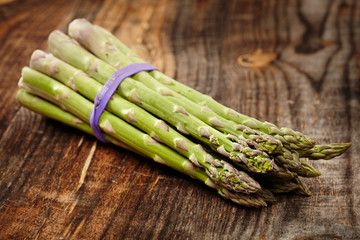 Raw asparagus on wooden board