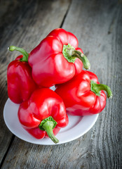 Red bell peppers on the wooden background