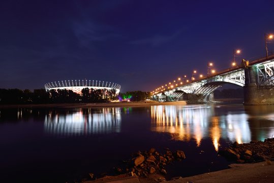 Poniatowski Bridge and National Stadium in Warsaw by night.