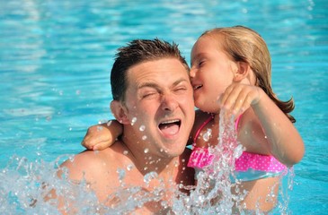 Father playing with his daughter in pool.