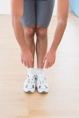 Man touching hands to feet in fitness studio