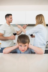 Obraz premium Boy covering ears while parents arguing