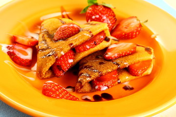 Two pancakes hearts with strawberry, chocolate, sugar milk