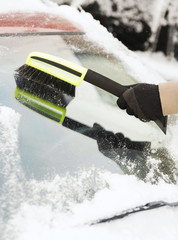 closeup of man cleaning snow from car