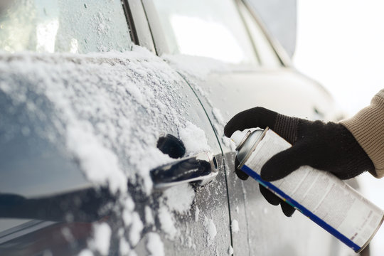 closeup of man hand with lock door de-icer