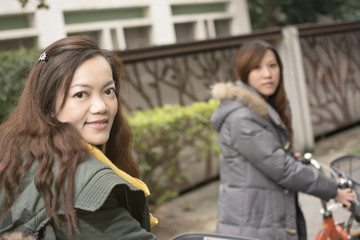 Young Asian woman riding bicycle with friends