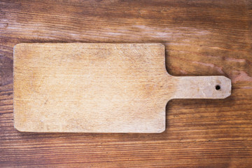 old wooden cutting board on a wooden background