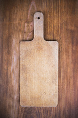 old wooden cutting board on a wooden background