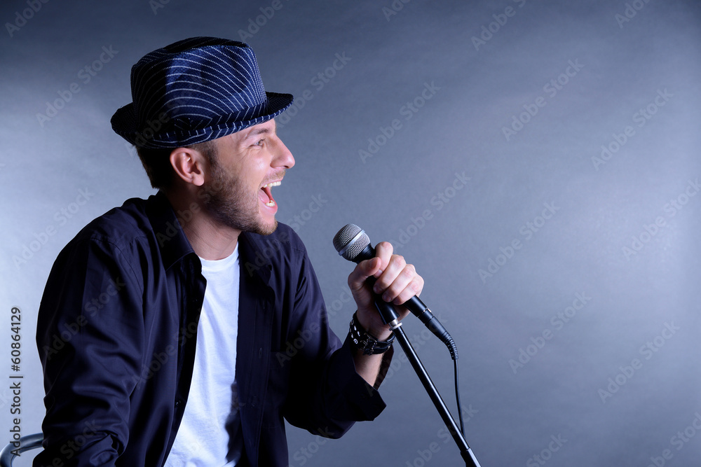 Poster Young musician singing, on gray background