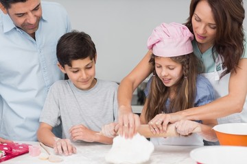 Family of four preparing cookies in the kitchen