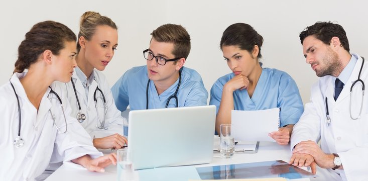 Medical team discussing over laptop