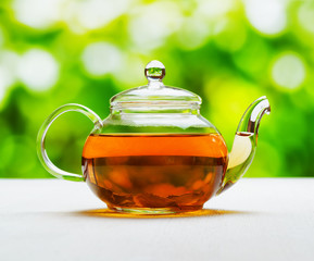 Teapot of fresh tea on natural background