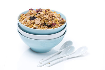 granola in a bowls and spoons, isolated on white