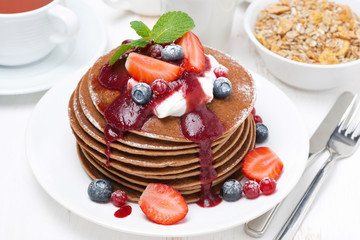 pancakes with cream, fruit sauce and fresh berries for breakfast